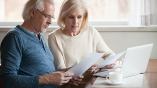 Worried couple reading documents calculating bills to pay