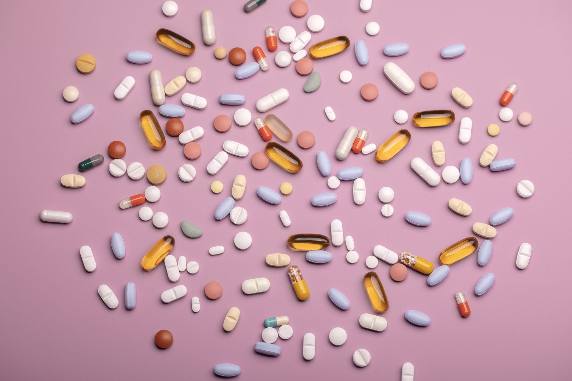 Hormone replacement therapy: Top view of various pills and tablets on the pink background