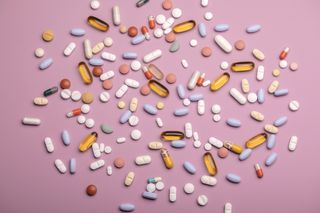 Hormone replacement therapy: Top view of various pills and tablets on the pink background