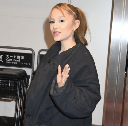 Actress/singer Ariana Grande is seen upon arrival at Haneda Airport on February 18, 2025 in Tokyo, Japan wearing a black puffer coat and lace tights