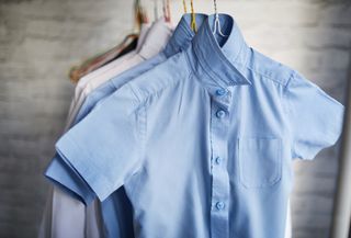 short sleeve school shirts in white and blue hanging on hangers