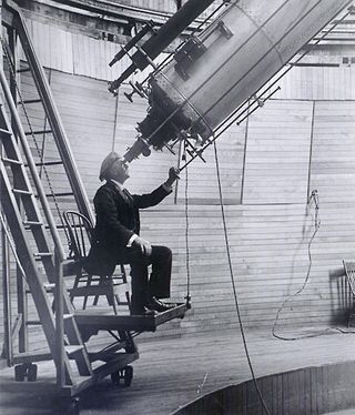 Astronomer Percival Lowell looks through the Clark Telescope.