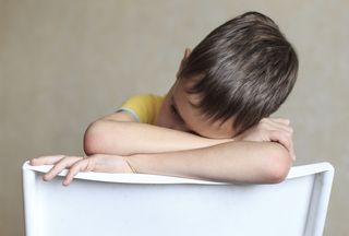 A little boy sits in "timeout"