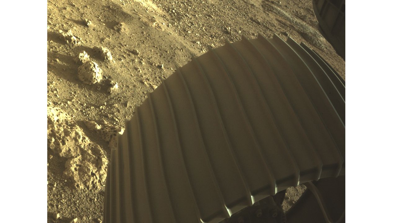 One of Perseverance&rsquo;s Hazard Detection Cameras (HazCams) snapped an up-close view of one of the rover&rsquo;s aluminum wheels. The rover has six wheels, each with its own individual motor. The six HazCams are located on the front and rear of the rover. This HazCam photo captures a detailed view of the rocky Martian soil beneath the rover&rsquo;s wheel.