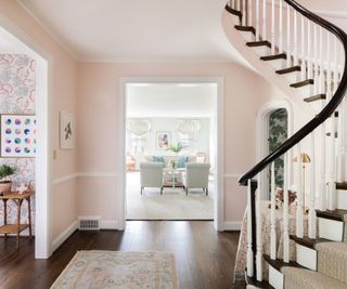 foyer with curved staircase and view to living room and powder room arched doorway