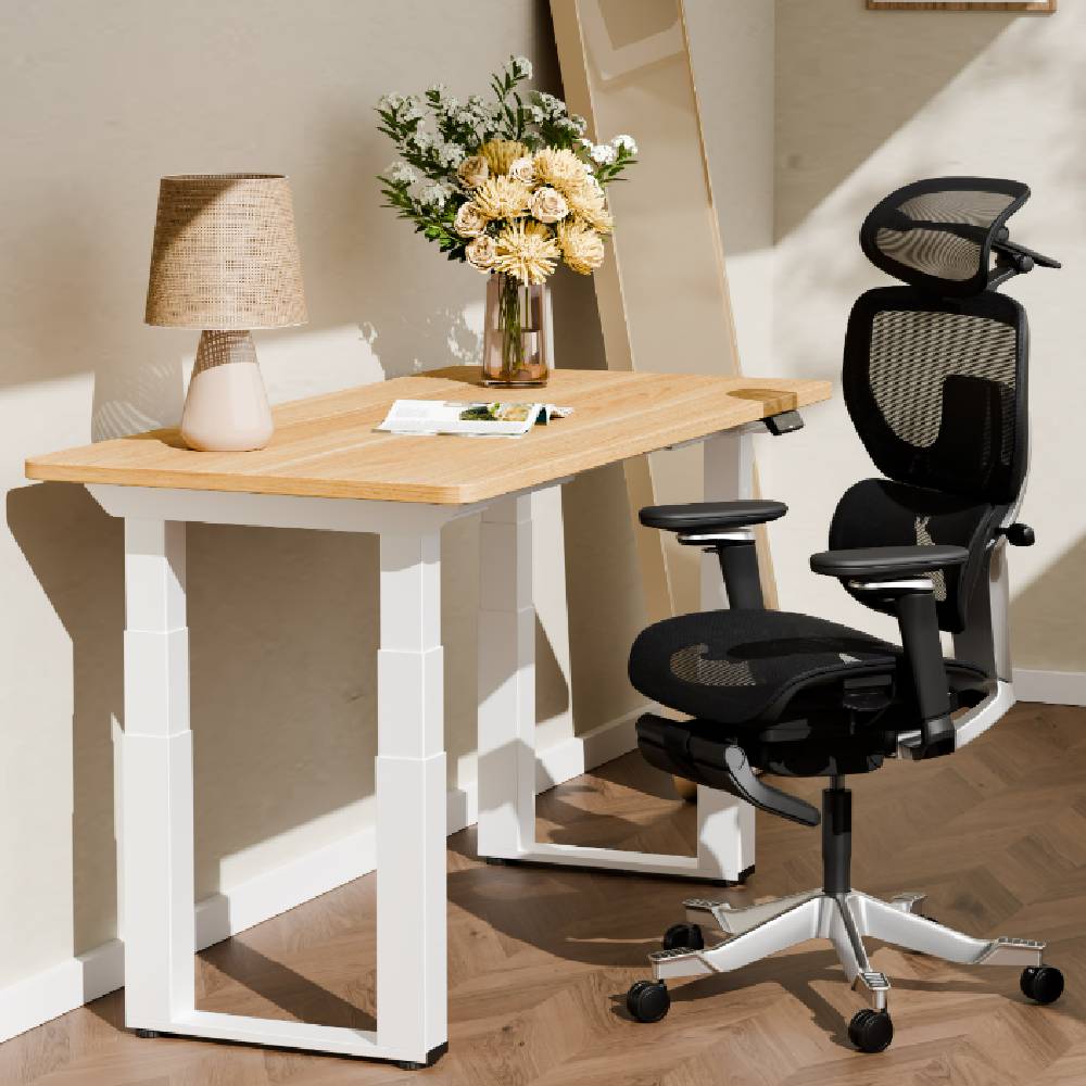 A modern office space with a light wood and white standing desk, and a black modern office chair from FlexiSpot.