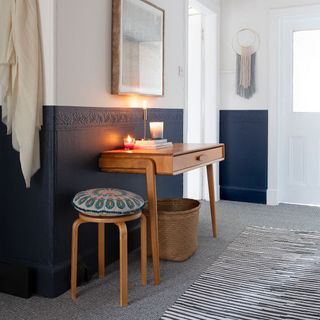 White hallways with navy blue painted below dado, wooden draw and s