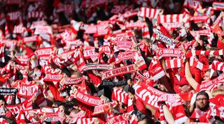 Union Berlin fans hold their scarves above their heads during the Bundesliga match between Union Berlin and Wolfsburg on 18 September, 2022 at the Stadion An der Alten Forsterei, Berlin, Germany