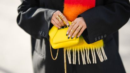 Dip powder nails - gradient manicure holding yellow handbag