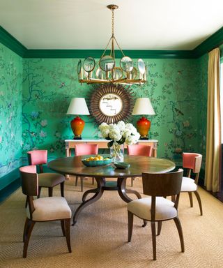 Dining room with deep green wallpaper and dark wood table