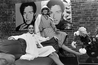 Models Carla Araque and Chris Royer pose in front of Andy Warhol paintings at designer Roy Halston's New York City townhouse.