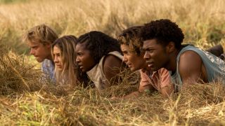 The Outer Banks cast peeks over grass while snooping. 