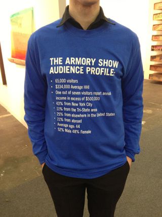 A blue jumper, words written on it include "The Armory Show Audience Profile". Stats written below include: 65,000 visitors; $334,000 Average HHI; One out of seven visitors report annual income in excess of $500,000; 43% from New York City; 11% from Tri-State area; 25$ from elsewhere in the US; 21% from abroad; Average age: 44; 52% male, 48% female.