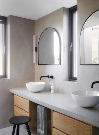 A plastered bathroom with a long bathroom vanity unit