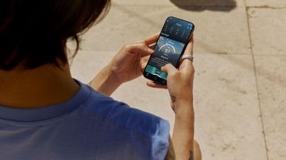 Female wearing the Oura smart ring and using the Oura app