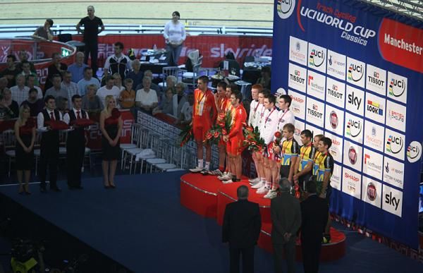 The men's team pursuit podium with the Great Britain team on top with gold medals