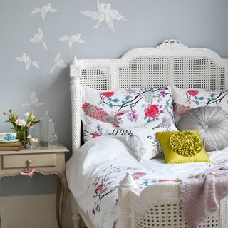 bedroom with wallpaper and bedlinen and bedside table
