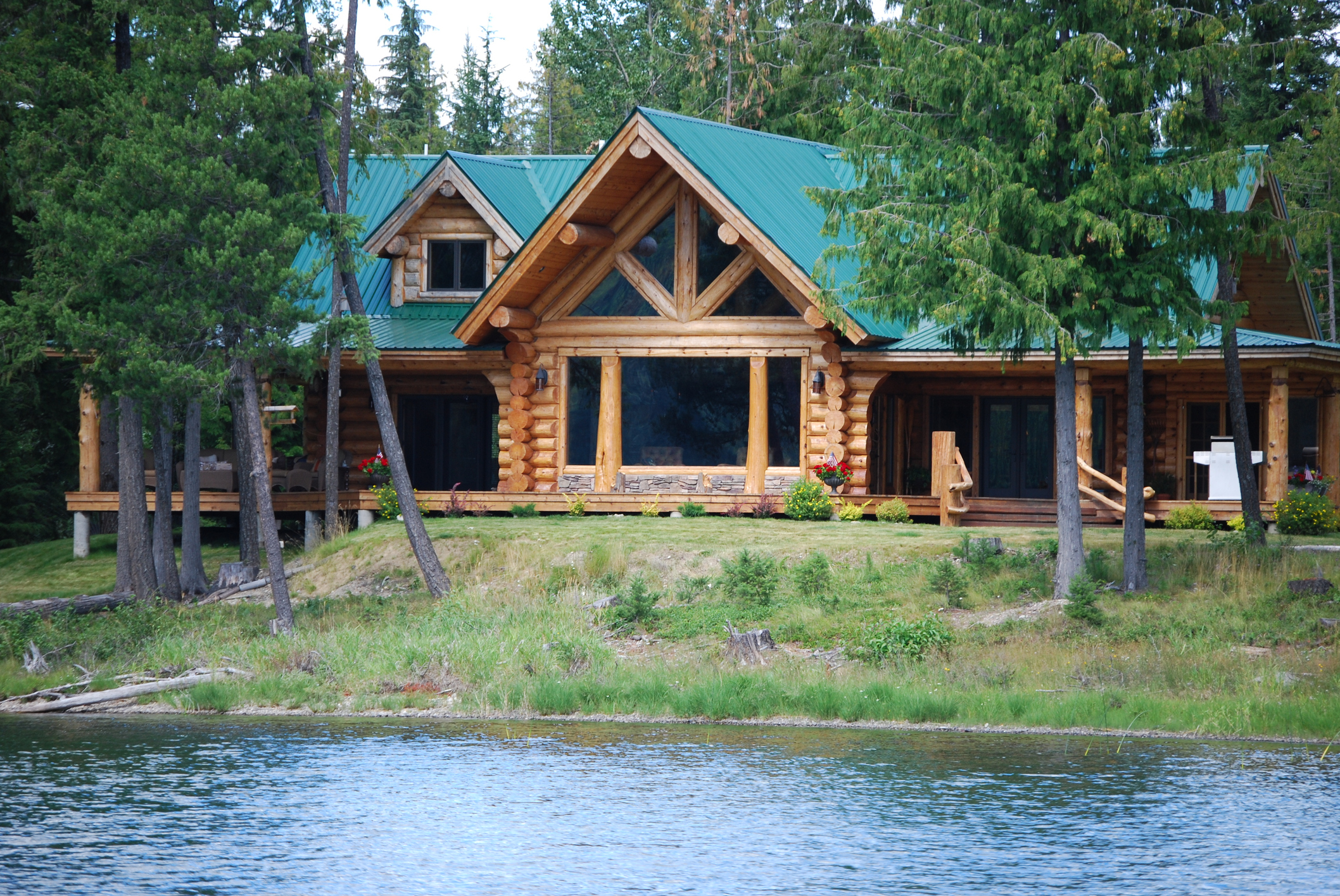 Montana log cabin on a lake with a forest in the background
