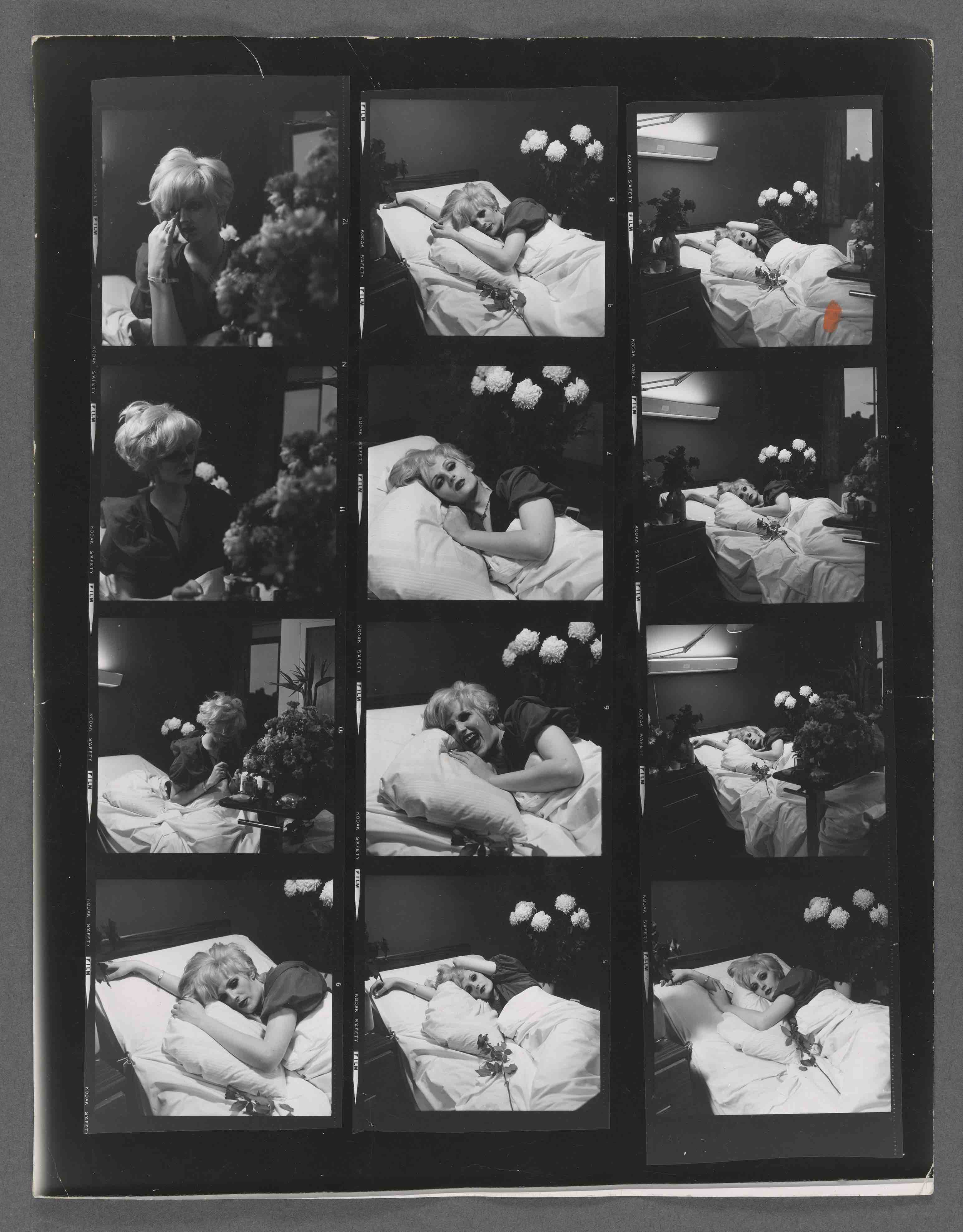 A black and white contact sheet comprising thirteen frames arranged in three columns, showing a blonde person lying in a hospital bed surrounded by white chrysanthemums, with a second person seated nearby in some frames