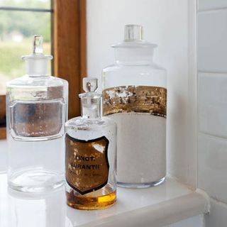 vintage pharmacy jars in white bathroom