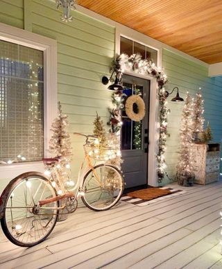 green painted porch with Christmas lights