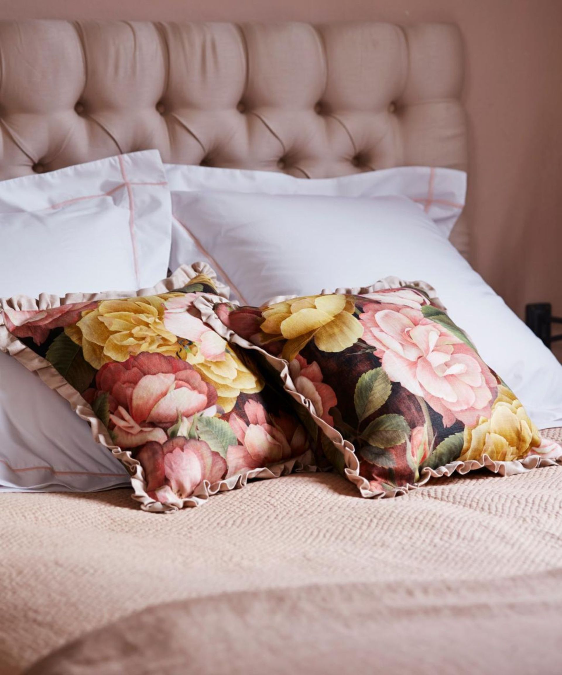 Pink floral cushions on a pink bed.