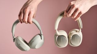 Person holding Sony WH-1000XM6 and Bowers & Wilkins Px7 S3