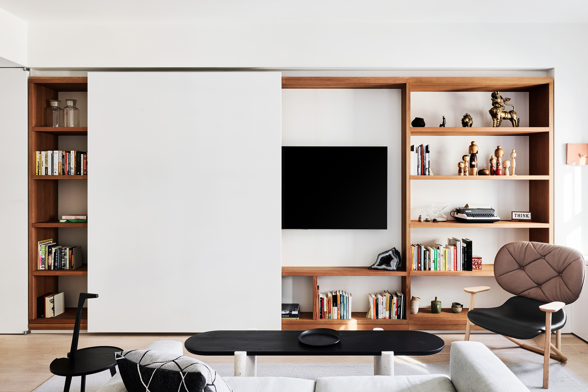 tv cabinet slid across to reveal TV in bookshelf in living room