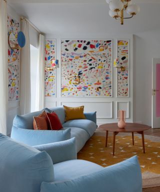 Living room with pastel blue sofa and colorful panelled walls