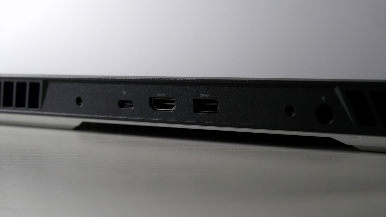 Dell G16 (7630) open on a white table, highlighting the ports on the back, including HDMI, USB Type-C, USB Type-A, and power jack.