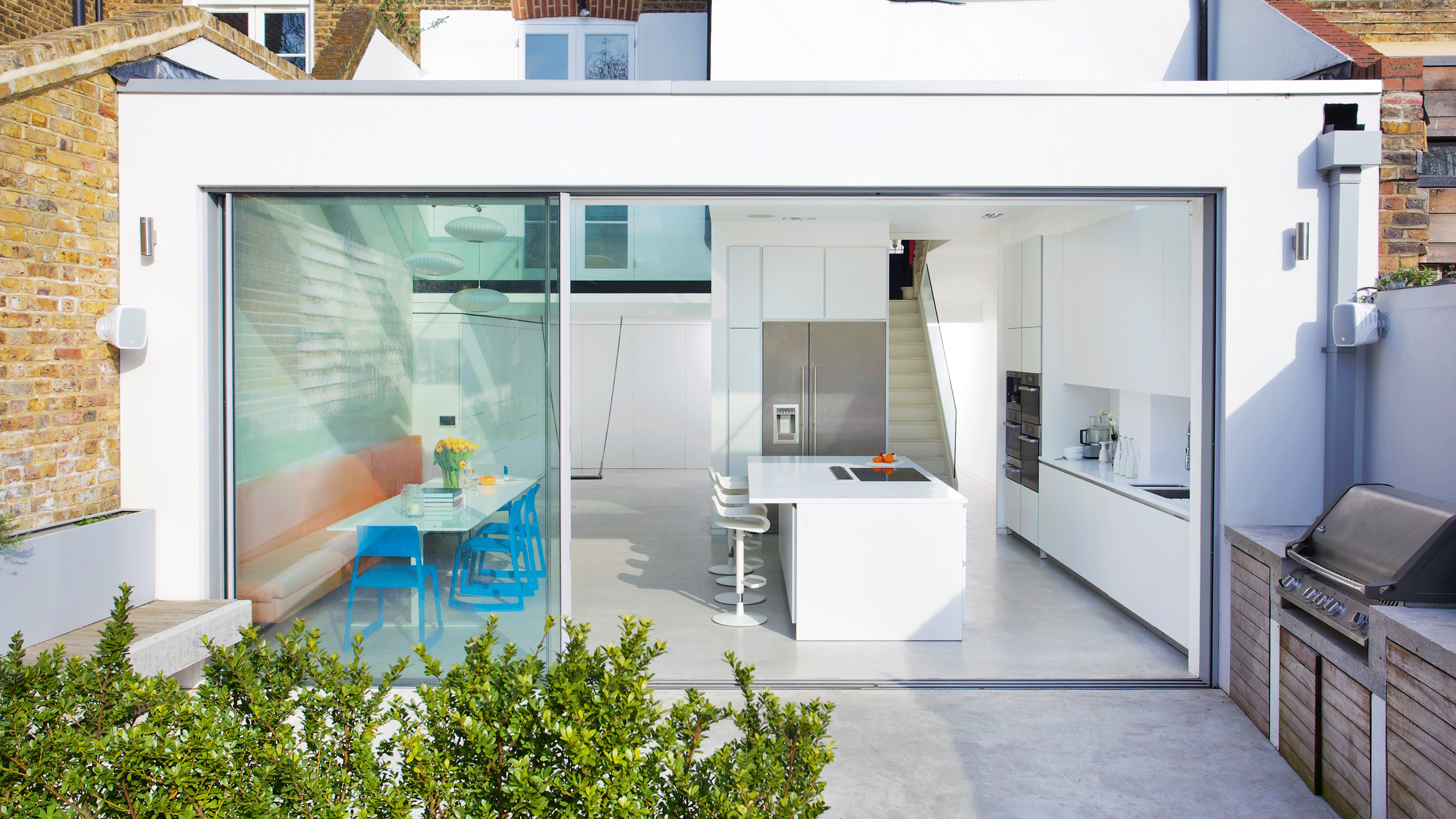 living room with white wall grey flooring and sliding doors to gallery 