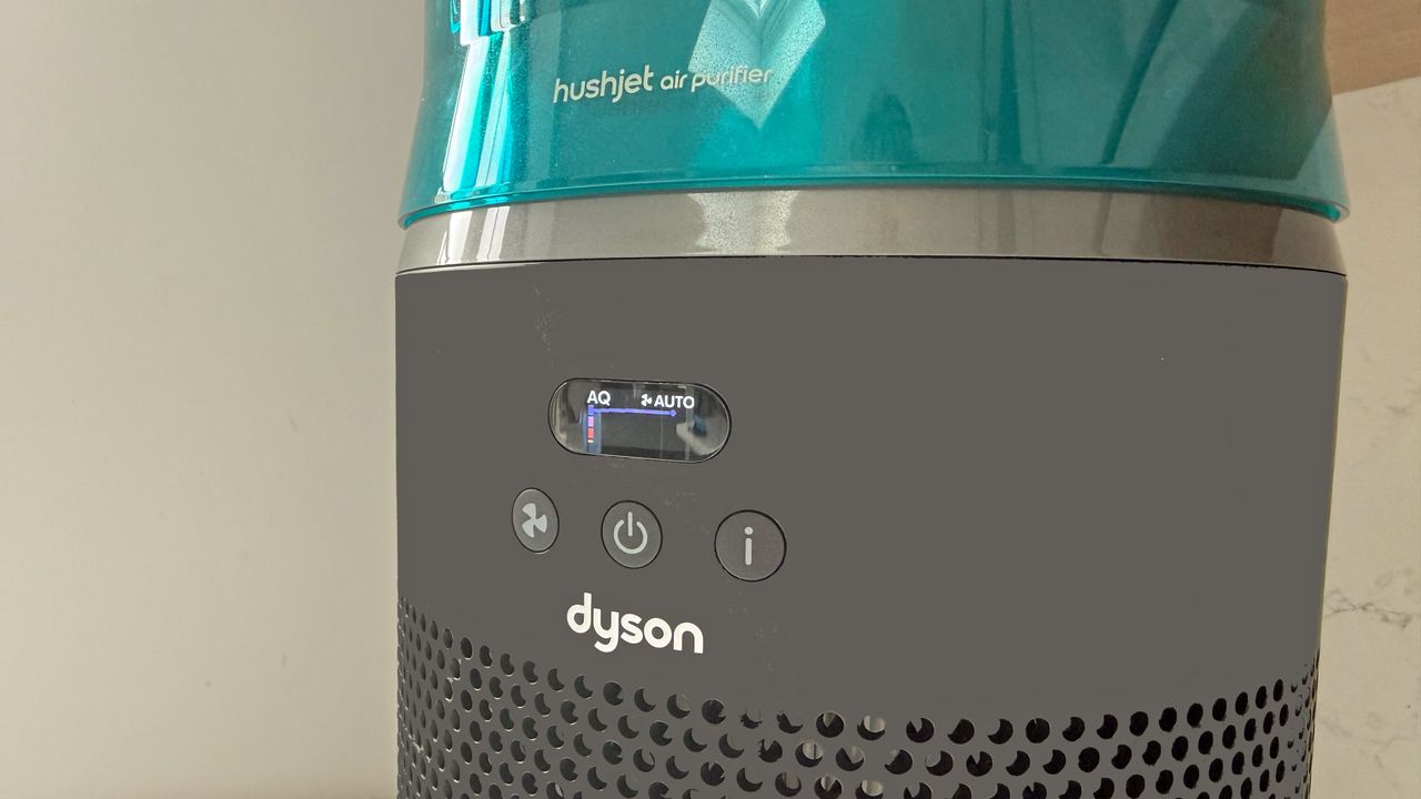 Close-up of the Dyson HushJet air purifier showing the front display and physical fan, power and information buttons under blue top section