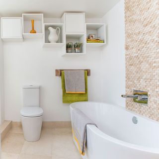 white walled bathroom with cabinets and green towels
