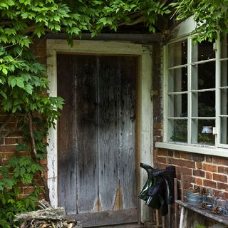 house entrance with rustic door and brick wall
