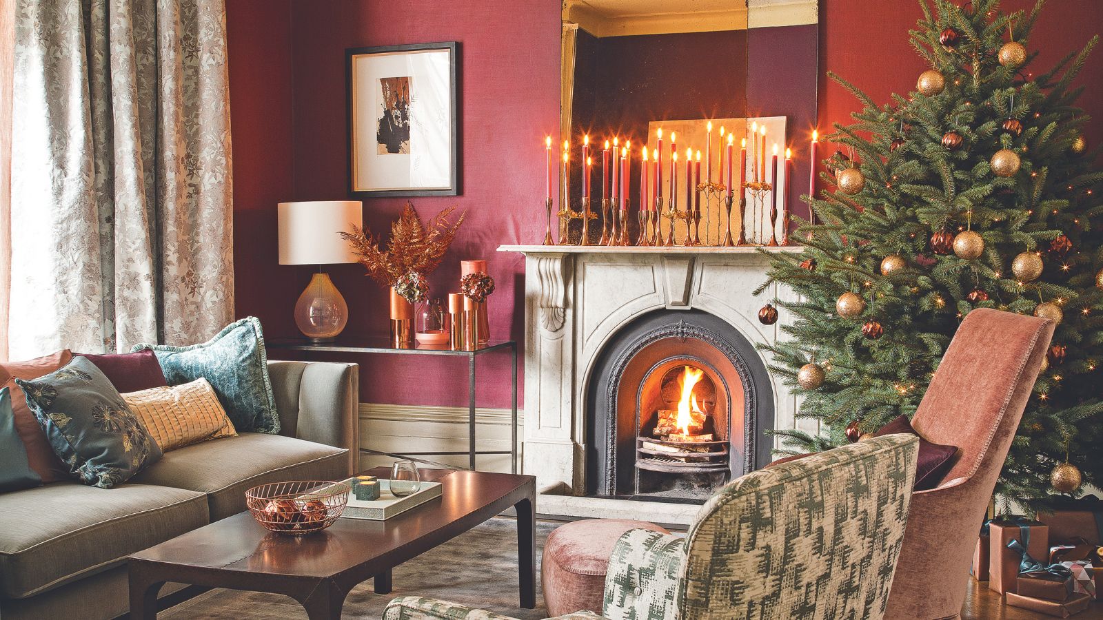 Red sitting room with fire, candles on the mantel and a Christmas tree