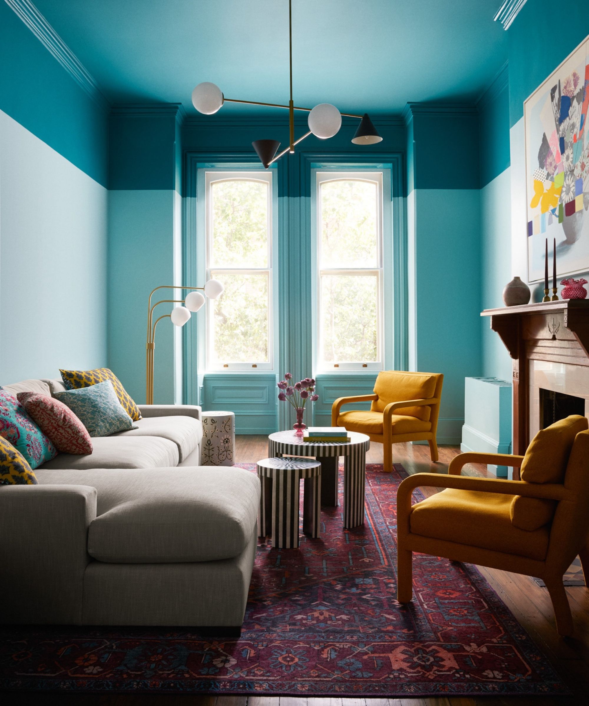 A modern living room with two-tone teal walls.