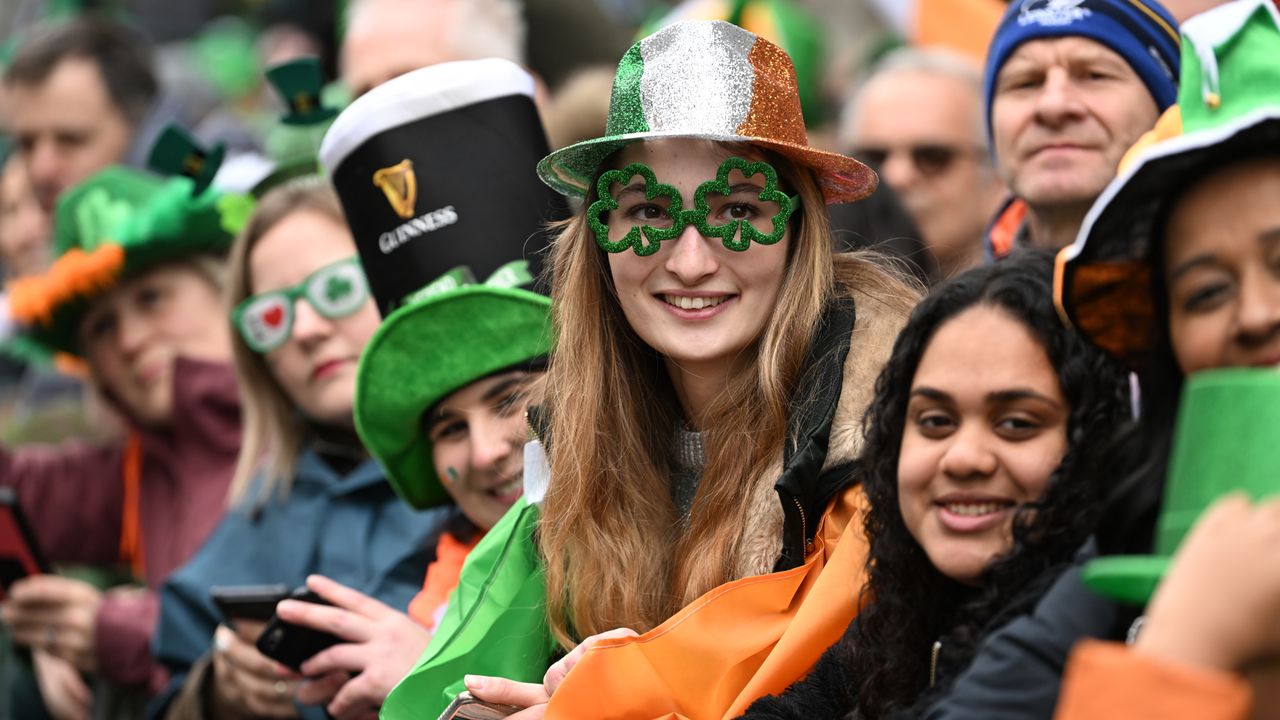 The crowd at 2023&#039;s St Patrick&#039;s Day parade in Dublin: with Irish tricolour flags and hats, a Guinness hat and shamrock glasses