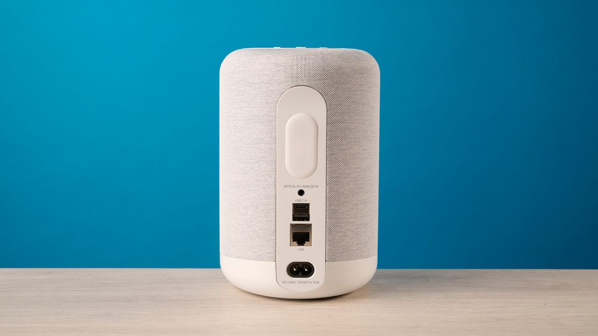 the bluesound pulse flex wi-fi speaker in pale gray photographed against the blue tom's guide background