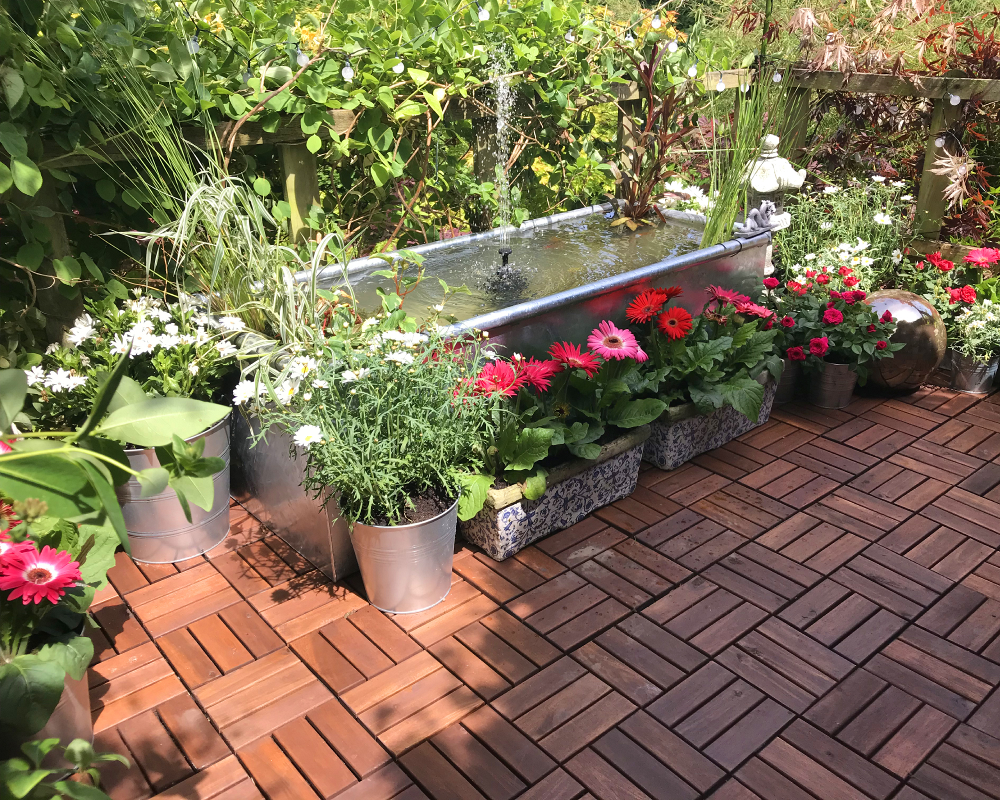 Large dipping tank creating easy irrigation and an attractive water feature in a garden, using a solar powered water fountain