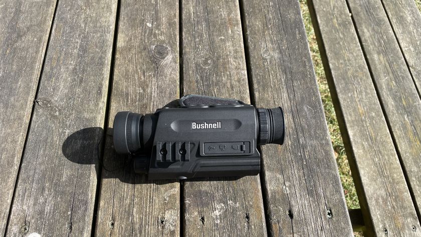 A Bushnell Equinox X650 Digital Night Vision monocular on a wooden bench.