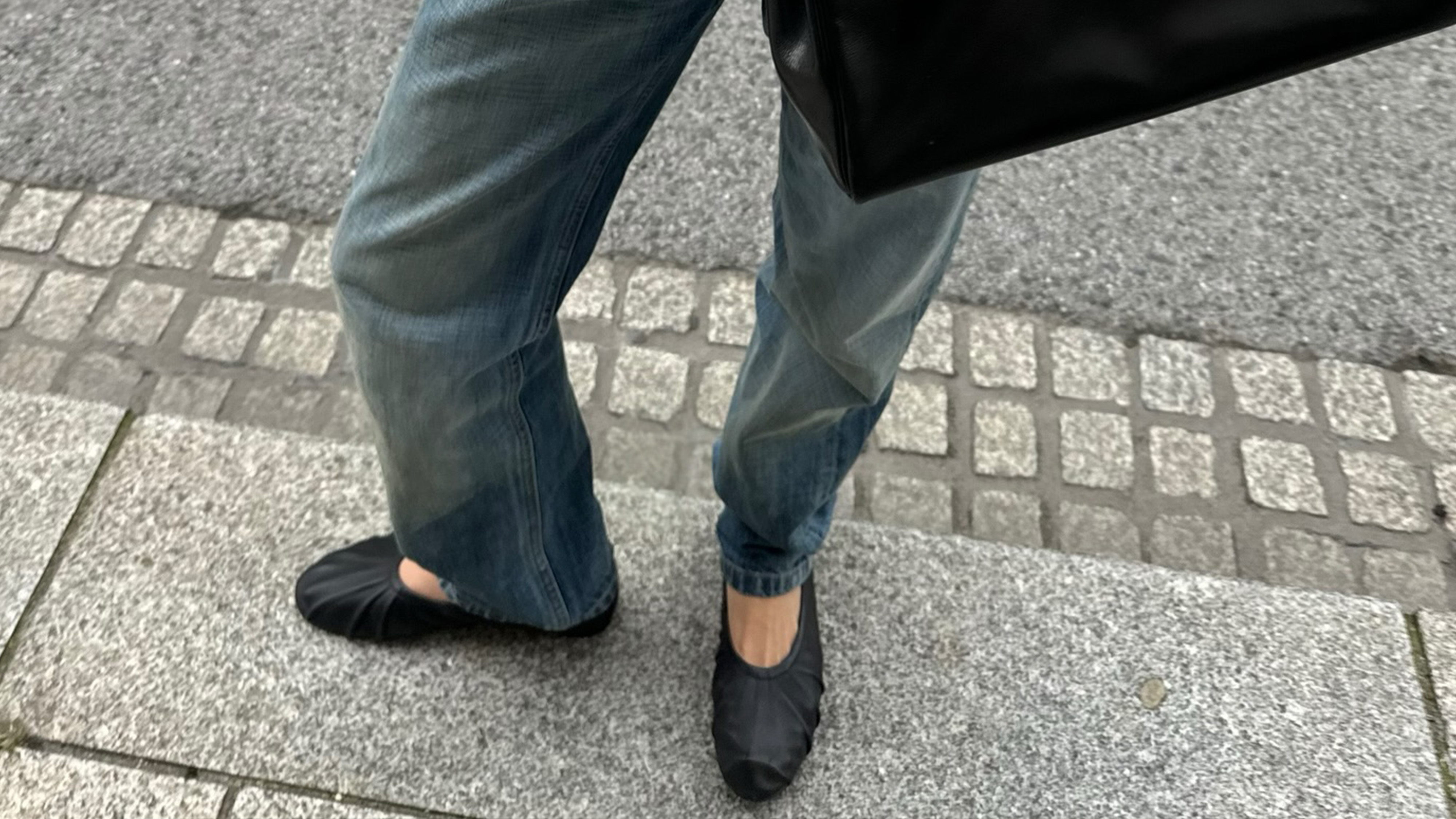 Woman wearing jeans and flats.