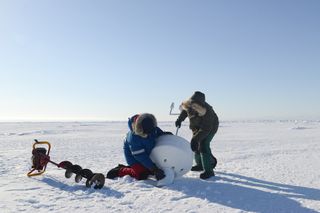 A research team deploys an ice beacon — a tool with sensors that measure GPS position, ice thickness, temperatures and other parameters — on sea ice in northern Alaska.