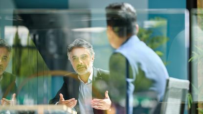 An older board member talks during a board meeting.