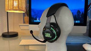 A JBL Quantum 810 Wireless gaming headset on a desk