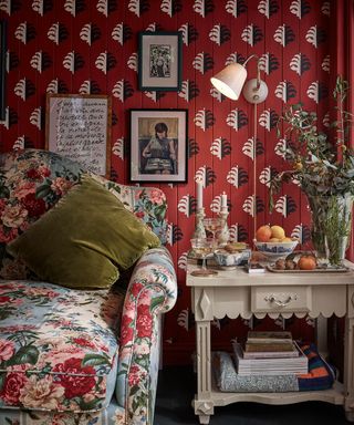 living room with red wallpaper and a table lamp