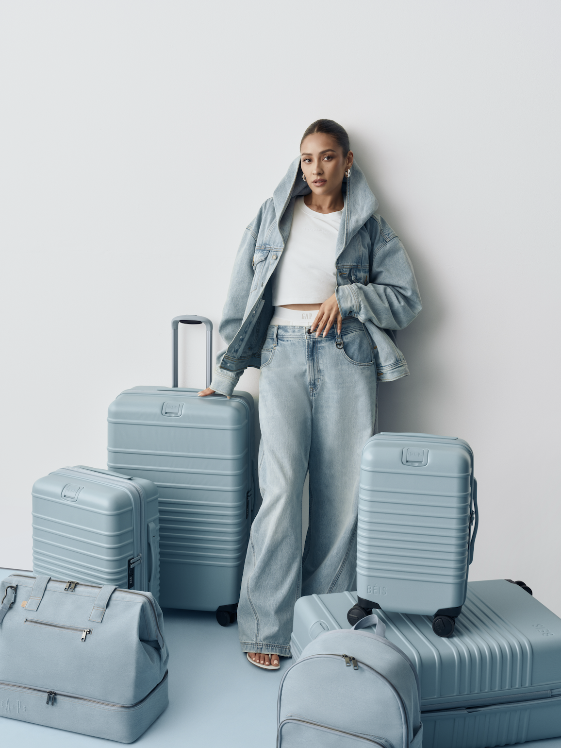 Shay Mitchell posed in head-to-toe denim alongside luggage from the BÉIS x Gap collaboration.