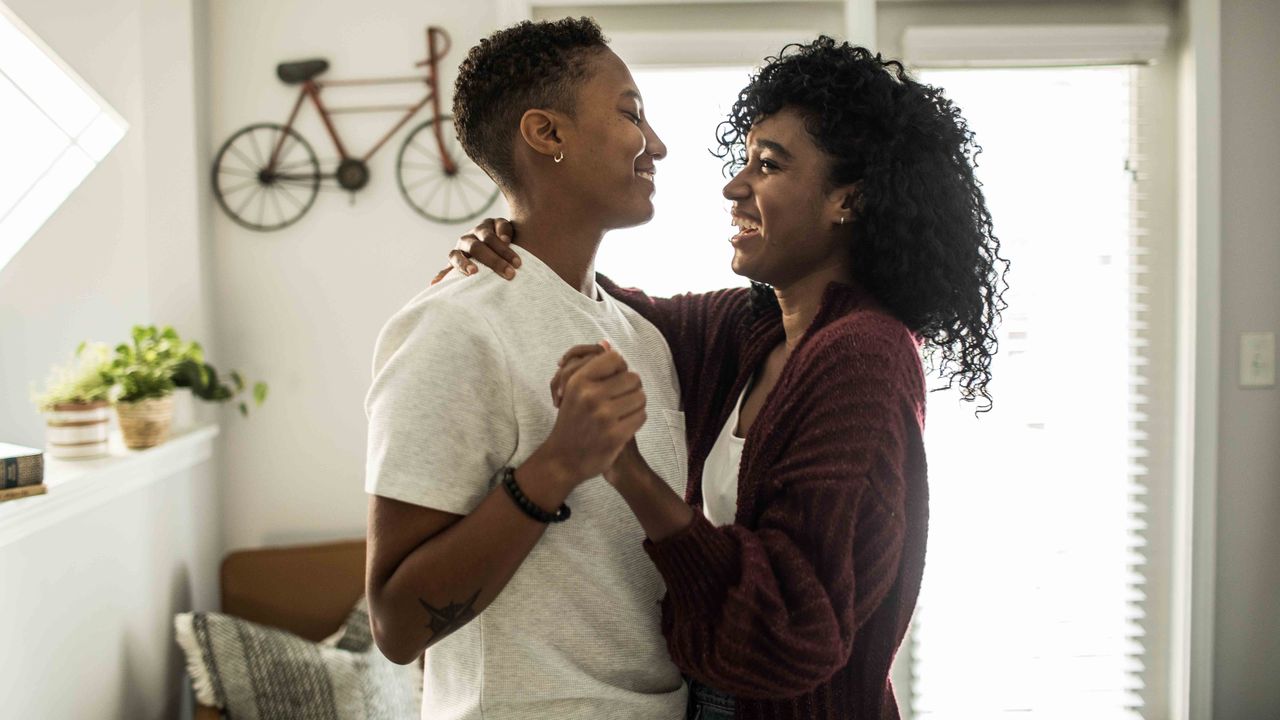 two black women dancing in their living room 