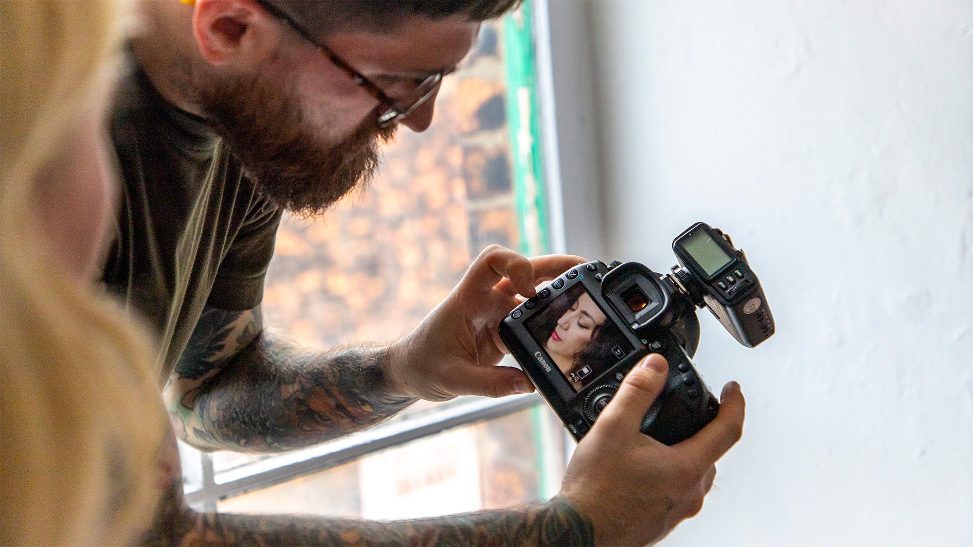 Person holding Canon camera and previewing image on the back