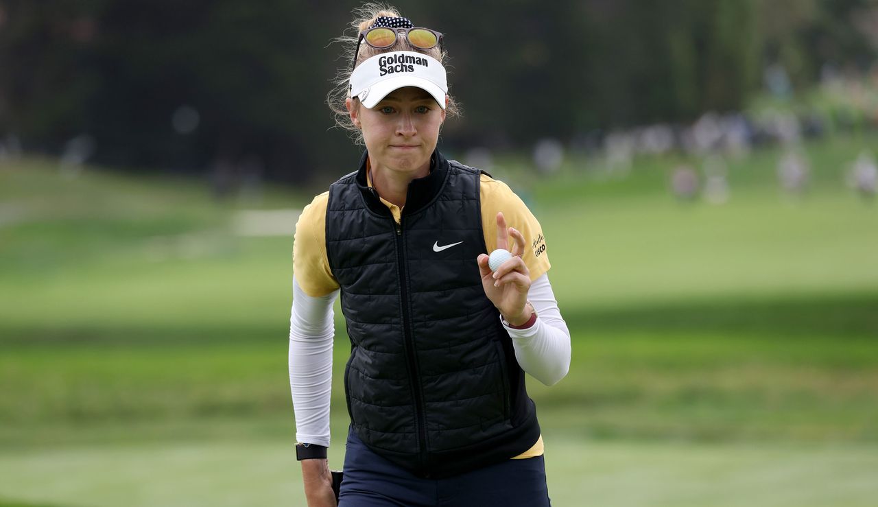 Nelly Korda waves to the crowd after holing a putt