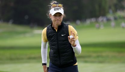 Nelly Korda waves to the crowd after holing a putt